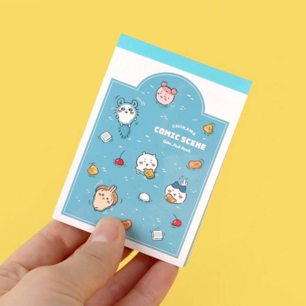 Officially licensed Chiikawa memo pads, one featuring a blue aquatic theme and the other a colorful comic book panel design. The interior pages show detailed character illustrations of Chiikawa, Hachiware, and Usagi.