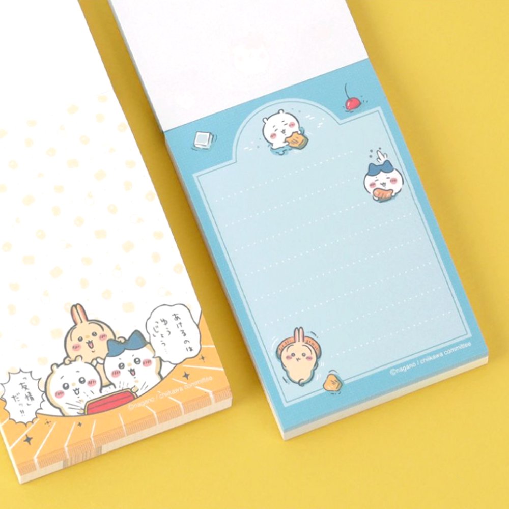 Officially licensed Chiikawa memo pads, one featuring a blue aquatic theme and the other a colorful comic book panel design. The interior pages show detailed character illustrations of Chiikawa, Hachiware, and Usagi.
