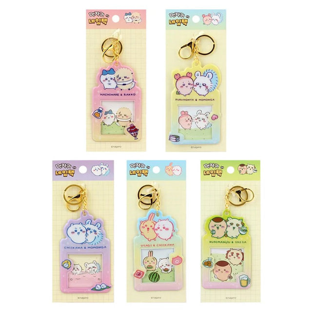 Colorful, officially licensed Chiikawa photo frame keychains featuring pastel gradients, character illustrations, and transparent window slots. Gold keyrings and lobster clasps are attached at the top of each charm holder.