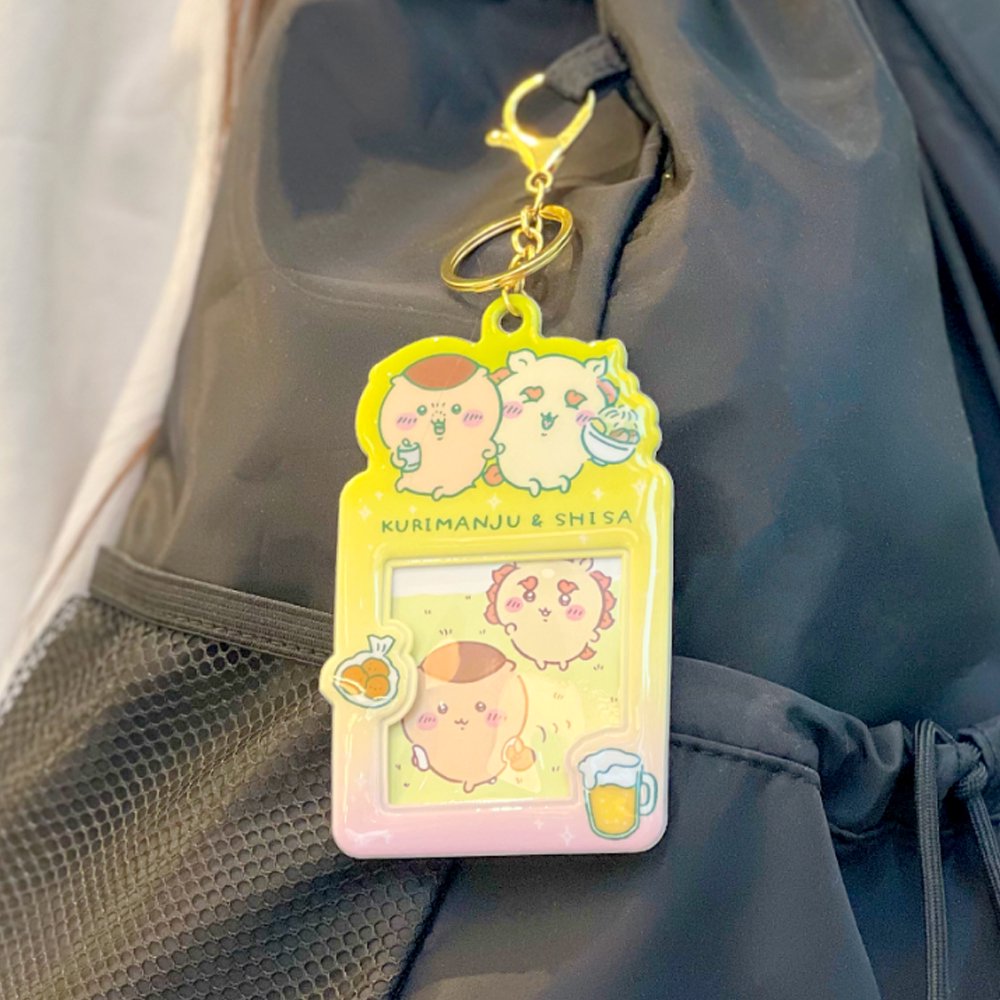 Colorful, officially licensed Chiikawa photo frame keychains featuring pastel gradients, character illustrations, and transparent window slots. Gold keyrings and lobster clasps are attached at the top of each charm holder.