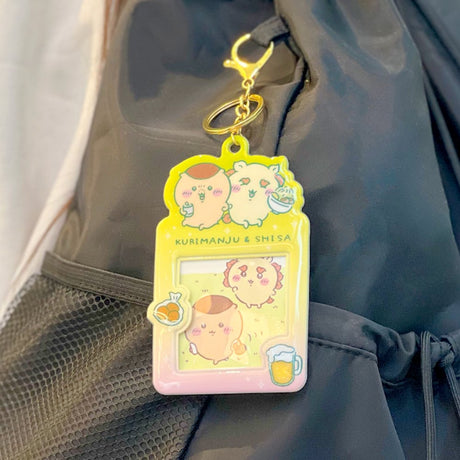 Colorful, officially licensed Chiikawa photo frame keychains featuring pastel gradients, character illustrations, and transparent window slots. Gold keyrings and lobster clasps are attached at the top of each charm holder.