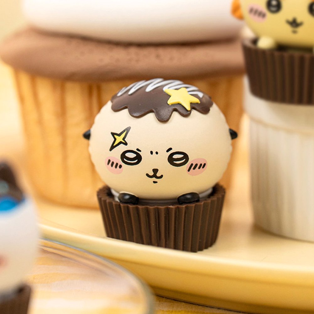 An official licensed collection of Chiikawa mystery Sweet Series blind boxes featuring brown and secret pink cupcake-themed packaging. Characters like Chiikawa, Hachiware, and Usagi are styled as cupcakes with frosting and sprinkles.