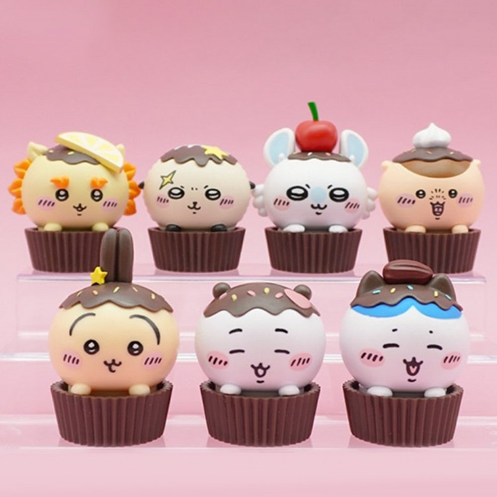 An official licensed collection of Chiikawa mystery Sweet Series blind boxes featuring brown and secret pink cupcake-themed packaging. Characters like Chiikawa, Hachiware, and Usagi are styled as cupcakes with frosting and sprinkles.
