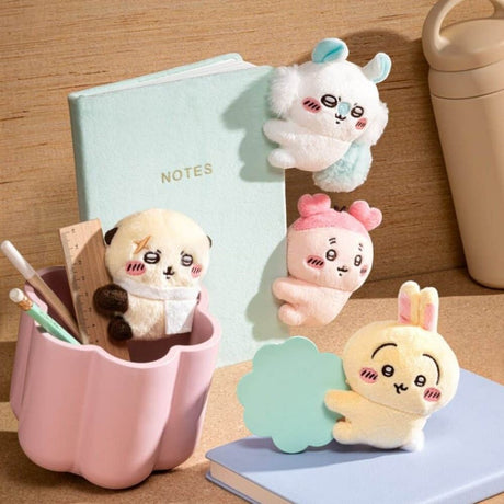 Officially licensed Chiikawa plush clip character assortment featuring Usagi clipped onto a spiral notebook cover alongside mini plush clips of Momonga, Kani, and Rakko
