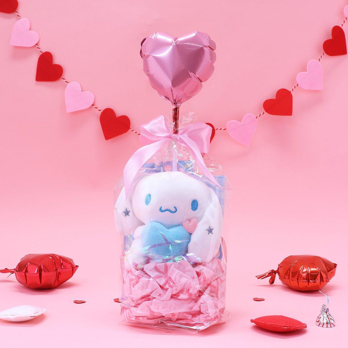 Official Sanrio Cinnamoroll Valentine's Day Plush Gift Set in a clear ribbon package with a red heart balloon. Includes a small Cinnamoroll  holding a pink heart and a collectible themed box, perfect for Kawaii aesthetic gift ideas.