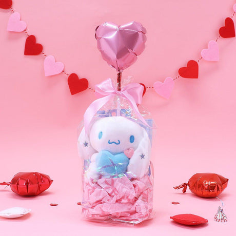 Official Sanrio Cinnamoroll Valentine's Day Plush Gift Set in a clear ribbon package with a red heart balloon. Includes a small Cinnamoroll  holding a pink heart and a collectible themed box, perfect for Kawaii aesthetic gift ideas.