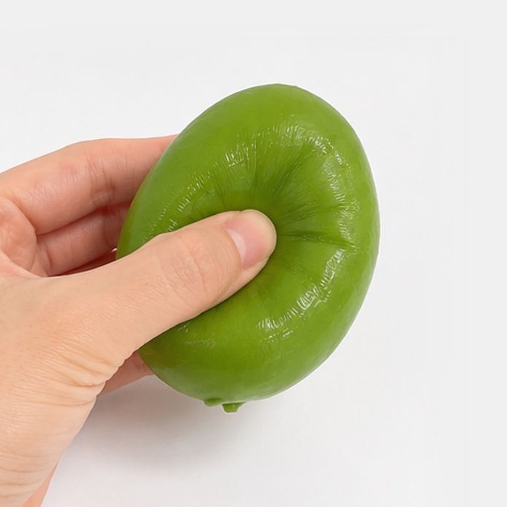 Hands squeezing a green Crunchy Mango Squishy Toy producing crisp ASMR crackle sound, featuring flexible TPR shell, color-changing chameleon effect,ideal party favor goodie bag filler, Christmas stocking stuffer, and holiday gift set.