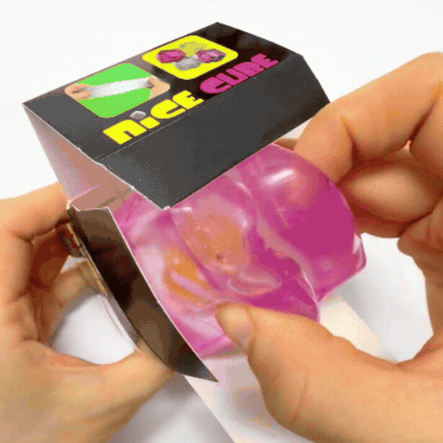 A close-up squeezing and molding of the Clear Pink Fish Ice Cube Squishy Toy. Demonstrating the ultra-soft, satisfyingly chewy jelly and mochi-like texture as a hand compresses the flexible ice block. Shows the high elasticity and slow-rising recovery of the embedded orange clownfish fidget, perfect for tactile stress relief, squishy ASMR satisfaction, and aesthetic sensory healing