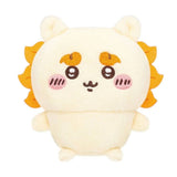 Front view of the officially licensed Shisa sitting plush toy from the Chiikawa Vol. 1 blind box series. A soft cream-colored plush character with a yellow-orange mane, bushy eyebrows, and pink blushed cheeks sitting on a white background.