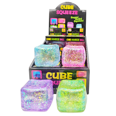 Translucent cube-shaped glitter squishy stress balls in purple, green, light blue, and pink filled with shimmering sparkles
