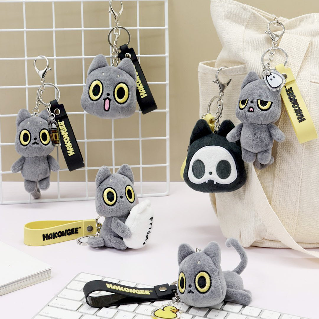 Plush keychains with Black cat design on a white grid background, featuring the brand 'Hakongee'.