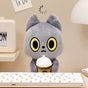 Black cat Plush toy cat with yellow eyes holding an ice coffee cup on a desk.