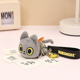 Black Cat Plush keychain with a yellow duck on a black strap labeled 'HAKONGEE' on a desk.