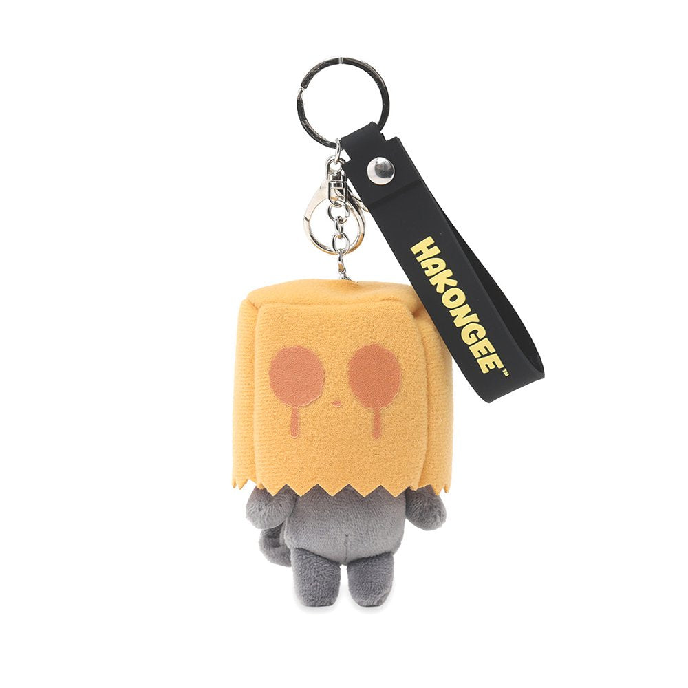 A grumpy Hakongee grey cat plush keychain wearing a brown paper bag over its head, officially licensed and made by WSL