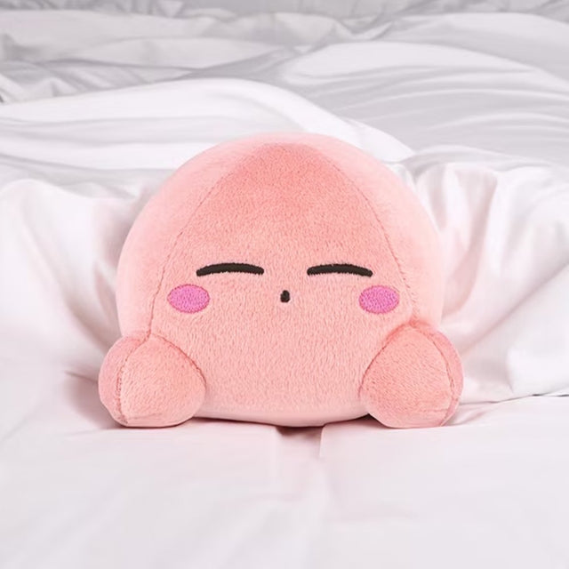 An officially licensed soft, round pink Kirby plush cushion resting peacefully with embroidered closed eyes and rosy cheeks
