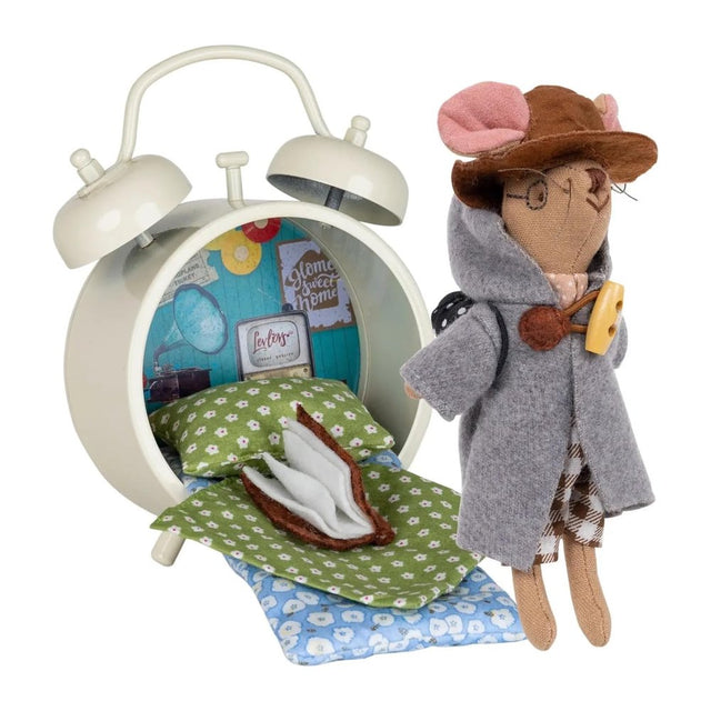 Levlovs' traveling mouse plush wearing a hooded coat and hat stands next to a cream-colored alarm clock structure outfitted as a tiny bedroom