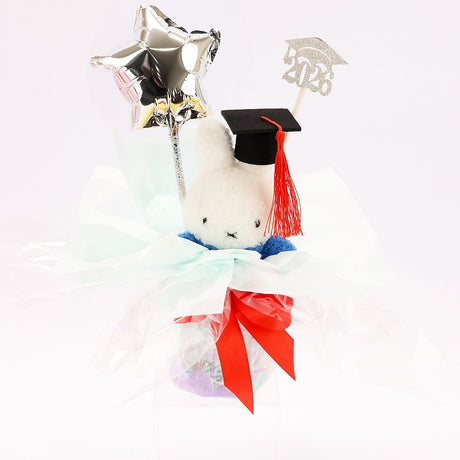 An officially licensed Class of 2026 Miffy graduation gift set featuring yellow, orange, green, and blue color Miffy plush and Boris plush wearing black graduation caps. The characters are arranged like a bouquet with silver star balloons and "Congrats Grad" decorations.