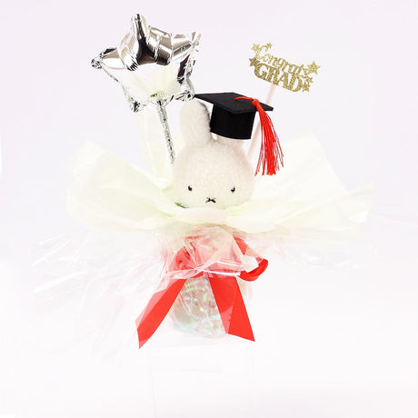 An officially licensed Class of 2026 Miffy graduation gift set featuring yellow, orange, green, and blue color Miffy plush and Boris plush wearing black graduation caps. The characters are arranged like a bouquet with silver star balloons and "Congrats Grad" decorations.