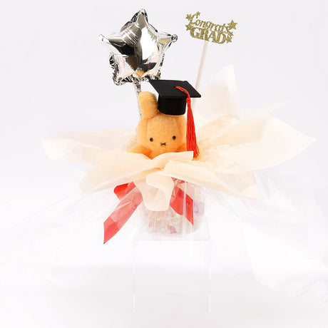 An officially licensed Class of 2026 Miffy graduation gift set featuring soft pink, orange, and blue color Miffy plush wearing black graduation caps. The characters are arranged like a bouquet with silver star balloons and "Congrats Grad" decorations.