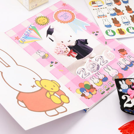 An officially licensed Class of 2026 Miffy graduation gift set featuring yellow, orange, green, and blue color Miffy plush and Boris plush wearing black graduation caps. The characters are arranged like a bouquet with silver star balloons and "Congrats Grad" decorations.