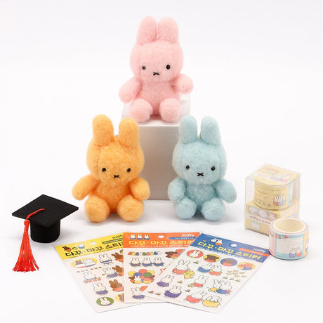 An officially licensed Class of 2026 Miffy graduation gift set featuring soft pink, orange, and blue color Miffy plush wearing black graduation caps. The characters are arranged like a bouquet with silver star balloons and "Congrats Grad" decorations.