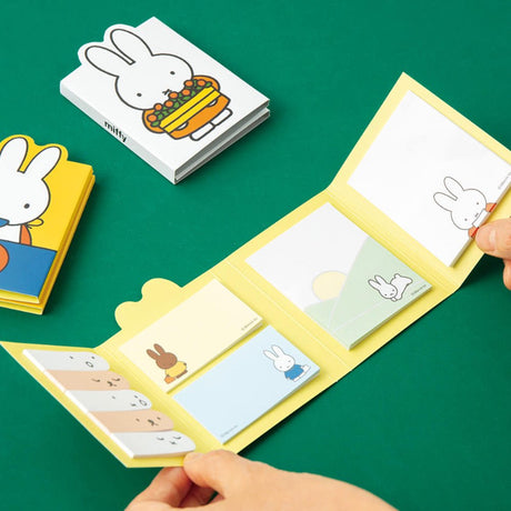 Officially licensed Miffy sticky note booklets featuring different covers—one showing Miffy holding a tray of orange flowers on a white background, and the other showing Miffy eating with a blue spoon on a yellow background
