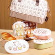 An officially licensed Miffy bento lunch box including a divider with a cream-colored base and dusty rose locking clips
