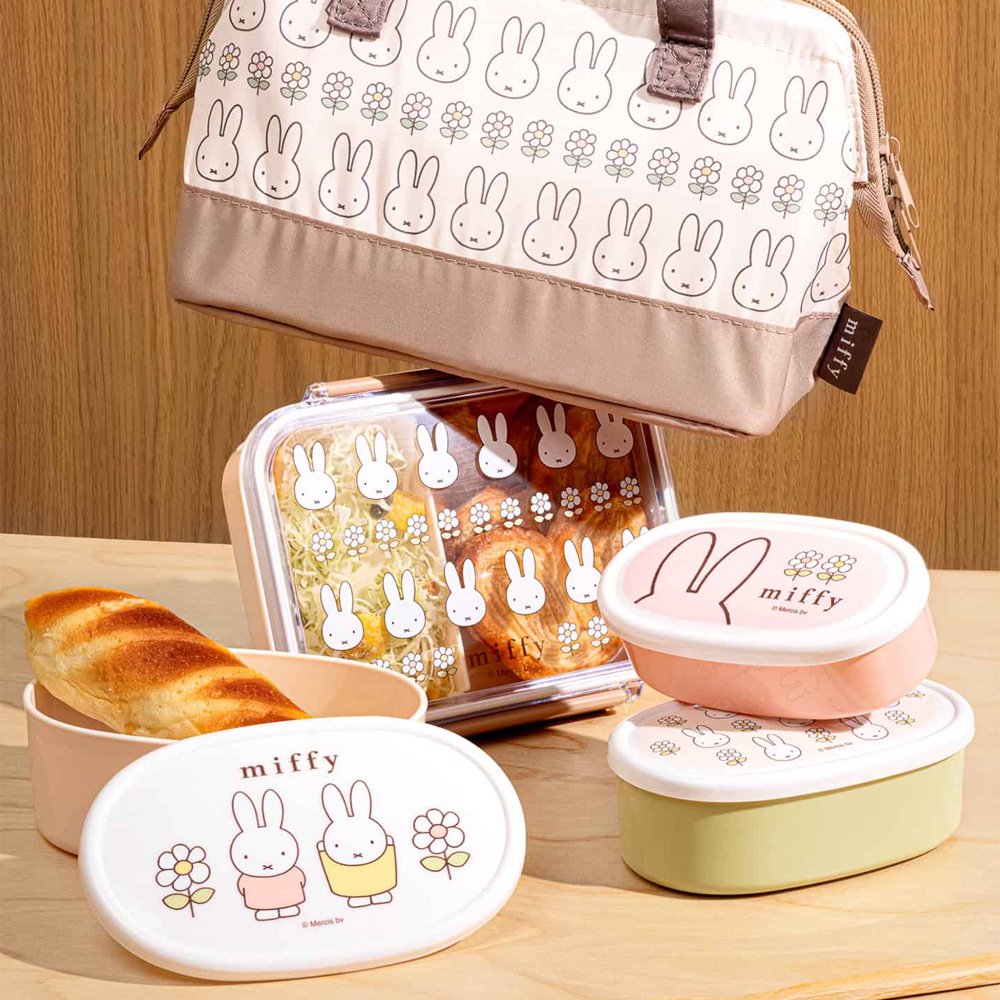 An officially licensed Miffy bento lunch box including a divider with a cream-colored base and dusty rose locking clips