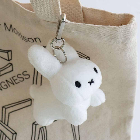 A Pure White Miffy bunny  plush keychain with a minimalist X-shaped mouth. This classic cream-white collector's item offers visual rest and childhood nostalgia for millennials decorating bag or your minimalist workspaces.