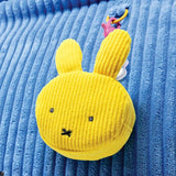 Officially licensed Miffy face shape Yellow corduroy pouch toy with n a blue textured background