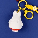 A collection of Miffy dream figure keychains in various poses, including Miffy reading a book, sleeping on a moon, and holding a yellow star, shown with green and blue accessories.