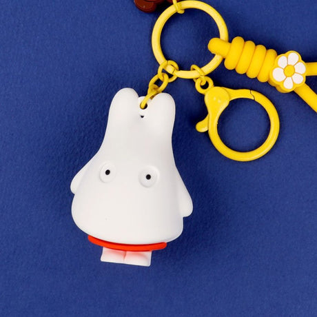 A collection of Miffy dream figure keychains in various poses, including Miffy reading a book, sleeping on a moon, and holding a yellow star, shown with green and blue accessories.