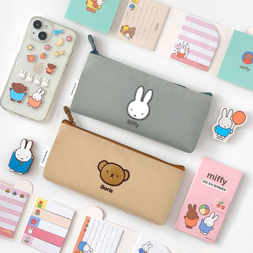 Two slim canvas pencil cases: one grey featuring an embroidered Miffy face and one tan featuring Boris Bear. Both cases have character-shaped zipper pulls.