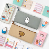 Two slim canvas pencil cases: one grey featuring an embroidered Miffy face and one tan featuring Boris Bear. Both cases have character-shaped zipper pulls.