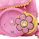 Officially licensed Miffy Flower Corduroy Coin Bag Charm clipped in pink backpack. Coin Pouch features Miffy peeking out from the center of a bold pink blossom, all crafted in soft, textured corduroy with embroidered details that make the design pop