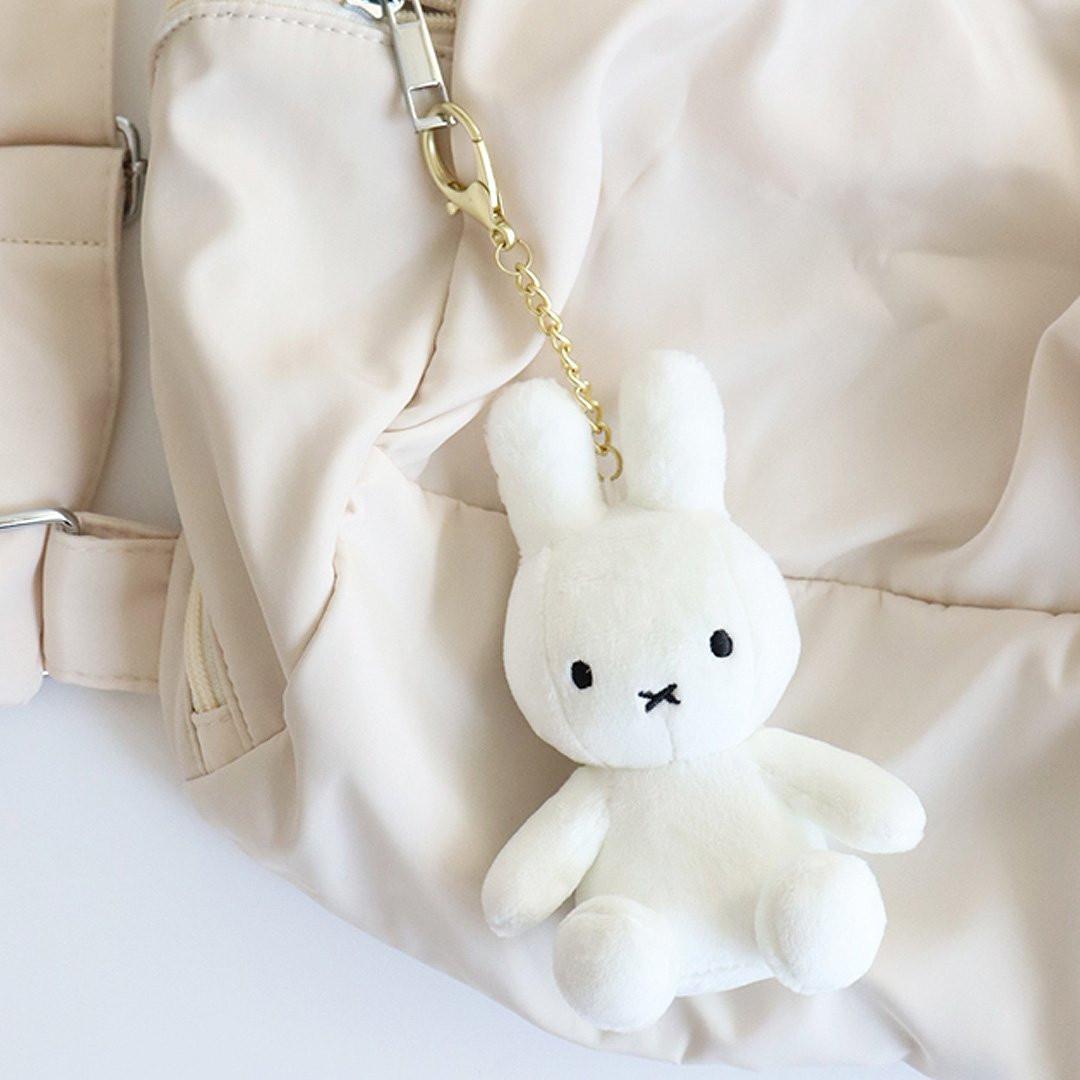 Official Miffy Glow in the Dark Mascot Plush Keychain and Bag Clip Charm; featuring a white rabbit plush with green embroidery that illuminates in darkness. A premium, functional Y2K aesthetic accessory for adult bag decor, night visibility, and unique nostalgic Stuffer. 