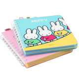 Officially licensed Miffy spiral notebooks in pink and blue, featuring die-cut character tabs of Miffy and friends along the top edge and white spiral binding.