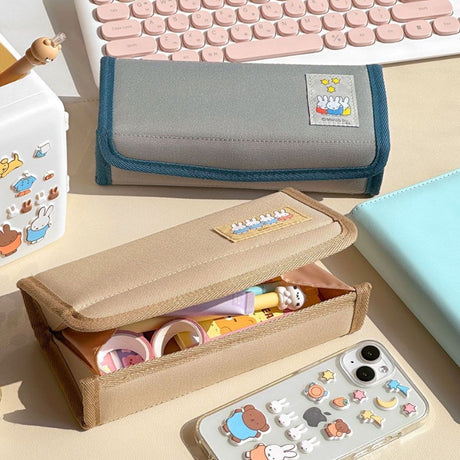 An officially licensed Miffy magnetic pencil case in beige and grey, featuring a colorful embroidered patch of Miffy characters on the front cover.