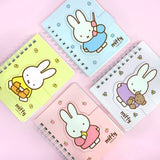 A series of officially licensed Miffy spiral notebooks in pastel pink, blue, and purple, featuring a large magnetic character buckle. The interior shows lined paper with a small Miffy graphic in the bottom corner, highlighting the notebook's functional and cute design.