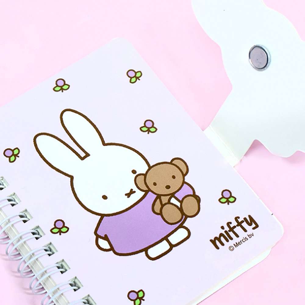 A series of officially licensed Miffy spiral notebooks in pastel pink, blue, and purple, featuring a large magnetic character buckle. The interior shows lined paper with a small Miffy graphic in the bottom corner, highlighting the notebook's functional and cute design.