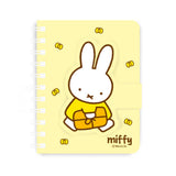 A series of officially licensed Miffy spiral notebooks in pastel pink, blue, and purple, featuring a large magnetic character buckle. The interior shows lined paper with a small Miffy graphic in the bottom corner, highlighting the notebook's functional and cute design.