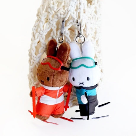 An officially licensed Miffy plush keychains from the Winter Sports series, featuring Miffy and Melanie dressed as a skier, figure skater, hockey player, and ski jumper in various colorful outfits.