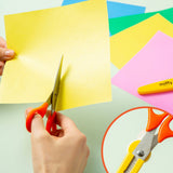 An officially licensed pair of Miffy safety scissors packaged on a colorful backing card, featuring bright orange handles and a protective yellow cap adorned with a die-cut Miffy bunny head.
