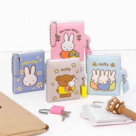An officially licensed collection of Miffy secret mini notebooks in soft pink, light blue, blue, and grey. Each notebook features a padded cover with Miffy or Boris Bear illustrations, a silver ball chain, and a color-coordinated miniature padlock with keys.