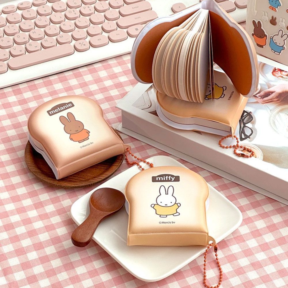 Officially licensed Miffy memo pads shaped like slices of toast. The pads feature a soft tan cover with character illustrations and include orange ball chains.
