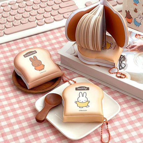 Officially licensed Miffy memo pads shaped like slices of toast. The pads feature a soft tan cover with character illustrations and include orange ball chains.