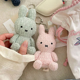 Four officially licensed Miffy textured tweed plush keychains lined up in pink, sage green, cream, and navy blue with attached silver keyrings