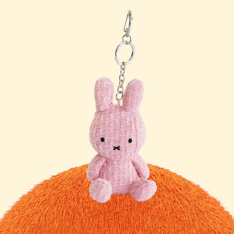 Four officially licensed Miffy textured tweed plush keychains lined up in pink, sage green, cream, and navy blue with attached silver keyrings