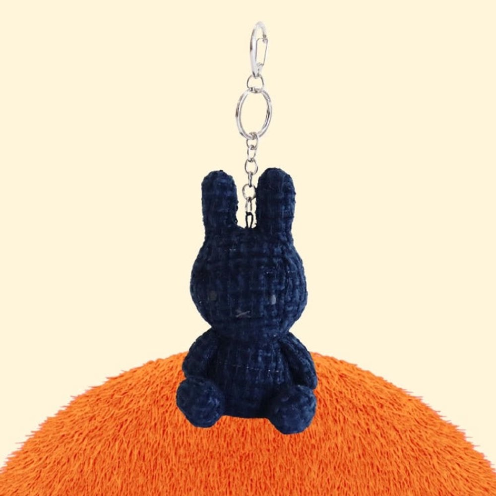 Four officially licensed Miffy textured tweed plush keychains lined up in pink, sage green, cream, and navy blue with attached silver keyrings
