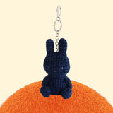 Four officially licensed Miffy textured tweed plush keychains lined up in pink, sage green, cream, and navy blue with attached silver keyrings